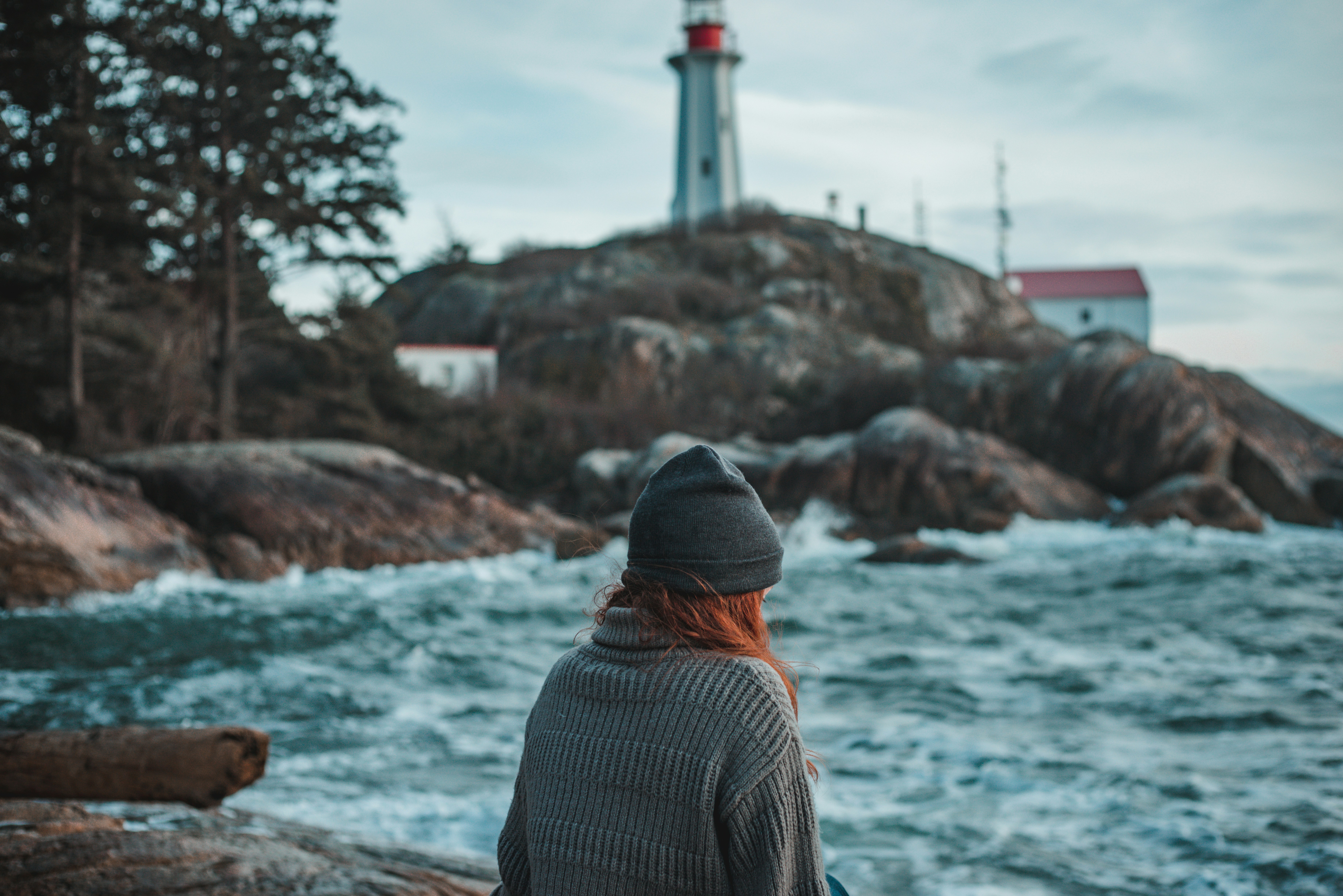 man in black and white striped shirt standing near body of water during daytime