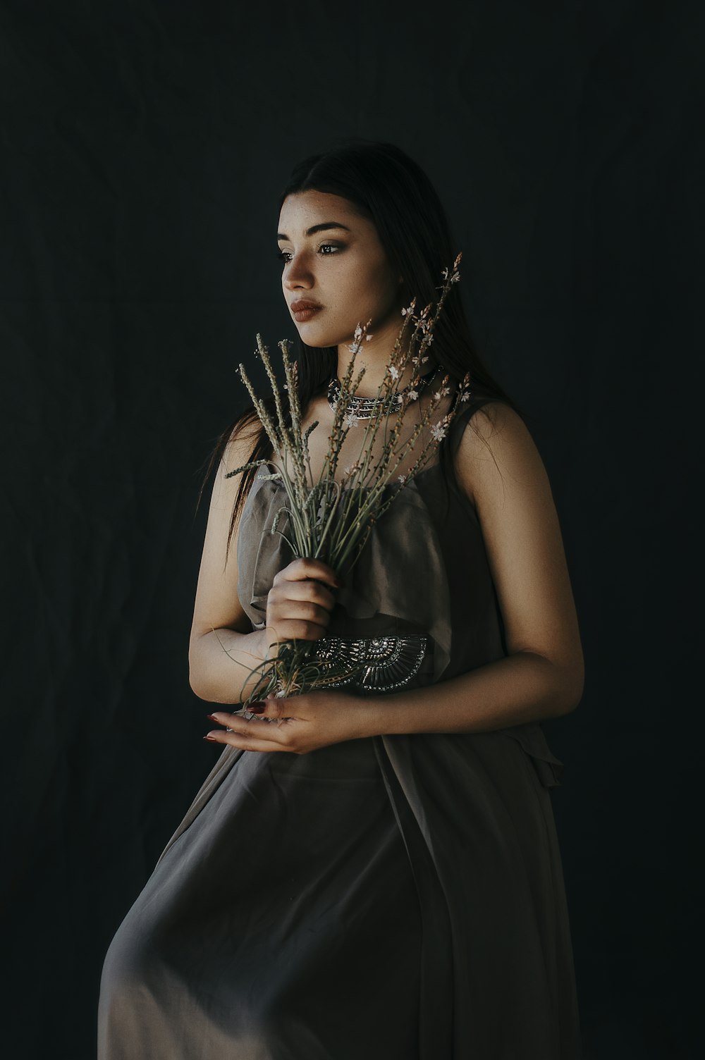 woman in black sleeveless dress holding silver and black trophy