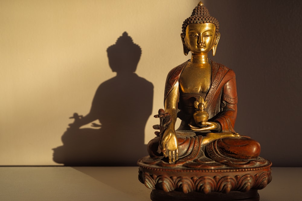 gold buddha figurine on white table