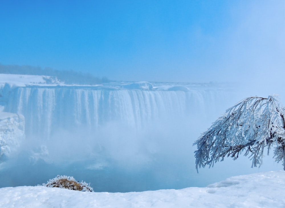 snow covered mountain near body of water during daytime