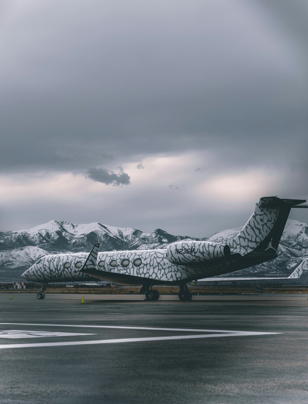 black and white fighter plane on gray asphalt road during daytime