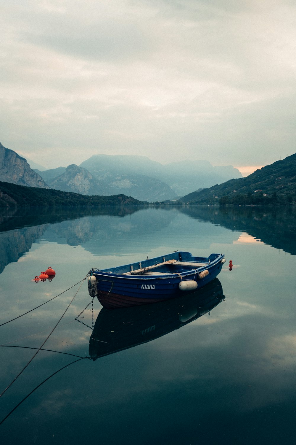 昼間、山の近くの湖に浮かぶ茶色のボート