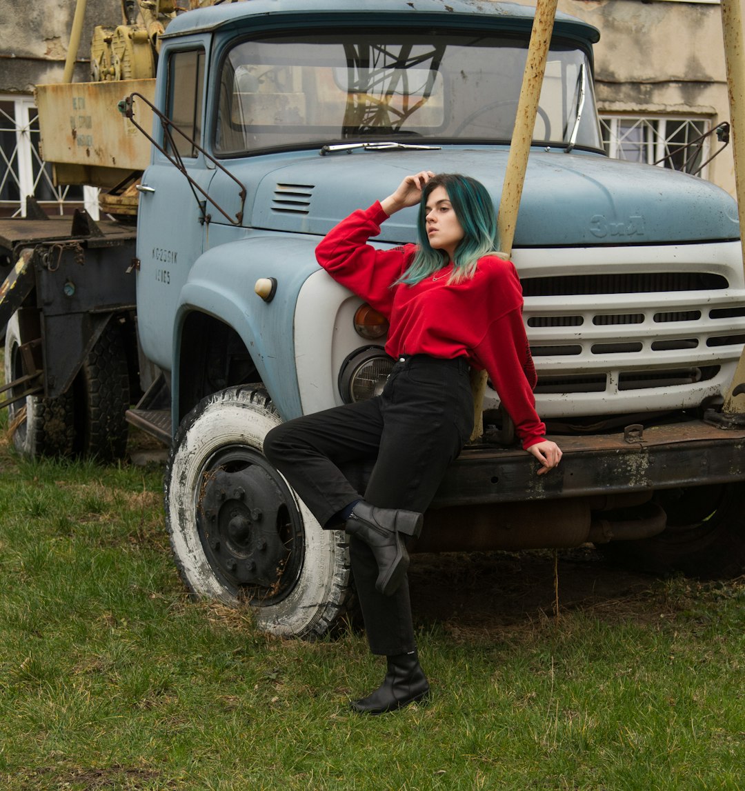 man in red hoodie sitting on white truck