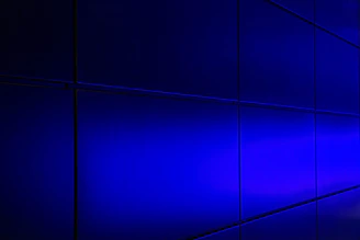 Subtle cyan and violet illuminated glass panel showing compliance data streams flowing securely.