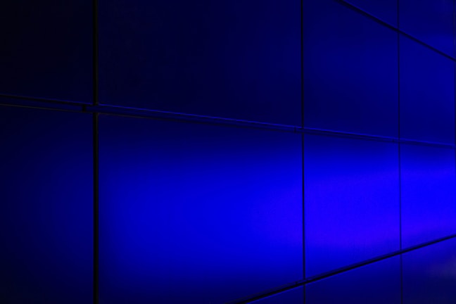 Grid layout of illuminated venture cards with subtle hover glow effects, set against a charcoal background with frosted glass overlays.