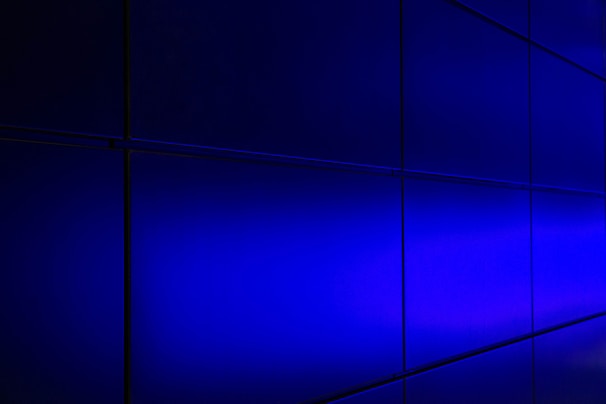 A sleek frosted glass panel glowing softly with bioluminescent emerald and electric blue highlights against a deep charcoal background.