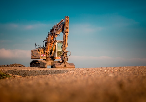 yellow and black excavator on brown sand during daytime