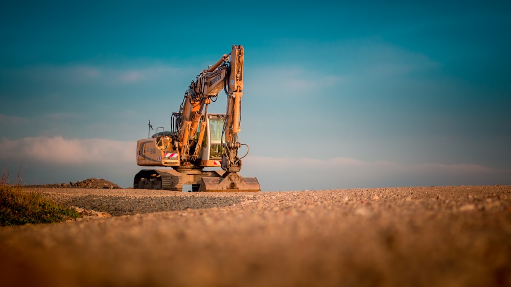 yellow and black excavator on brown sand during daytime