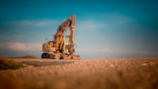 yellow and black excavator on brown sand during daytime