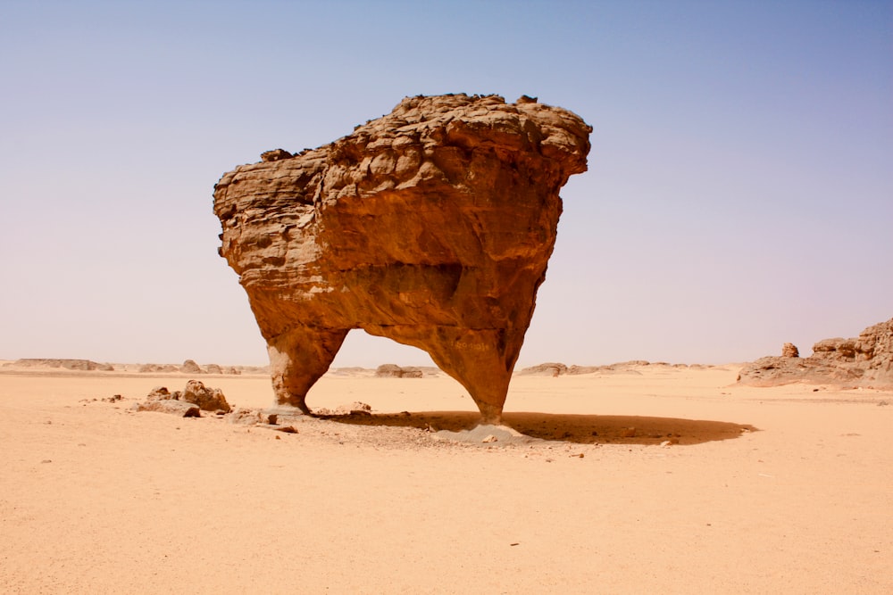 昼間の茶色い砂の上の茶色の岩層