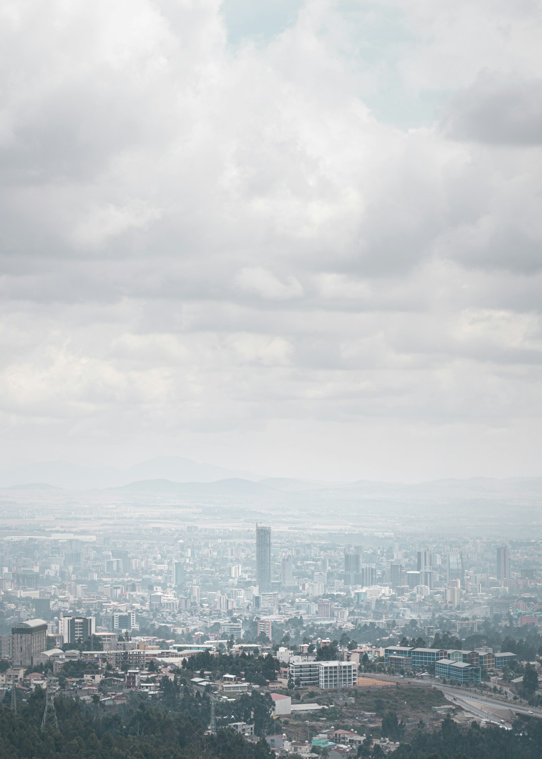 city skyline under white clouds during daytime