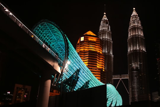 green and brown lighted building during night time in Petronas Twin Towers Malaysia