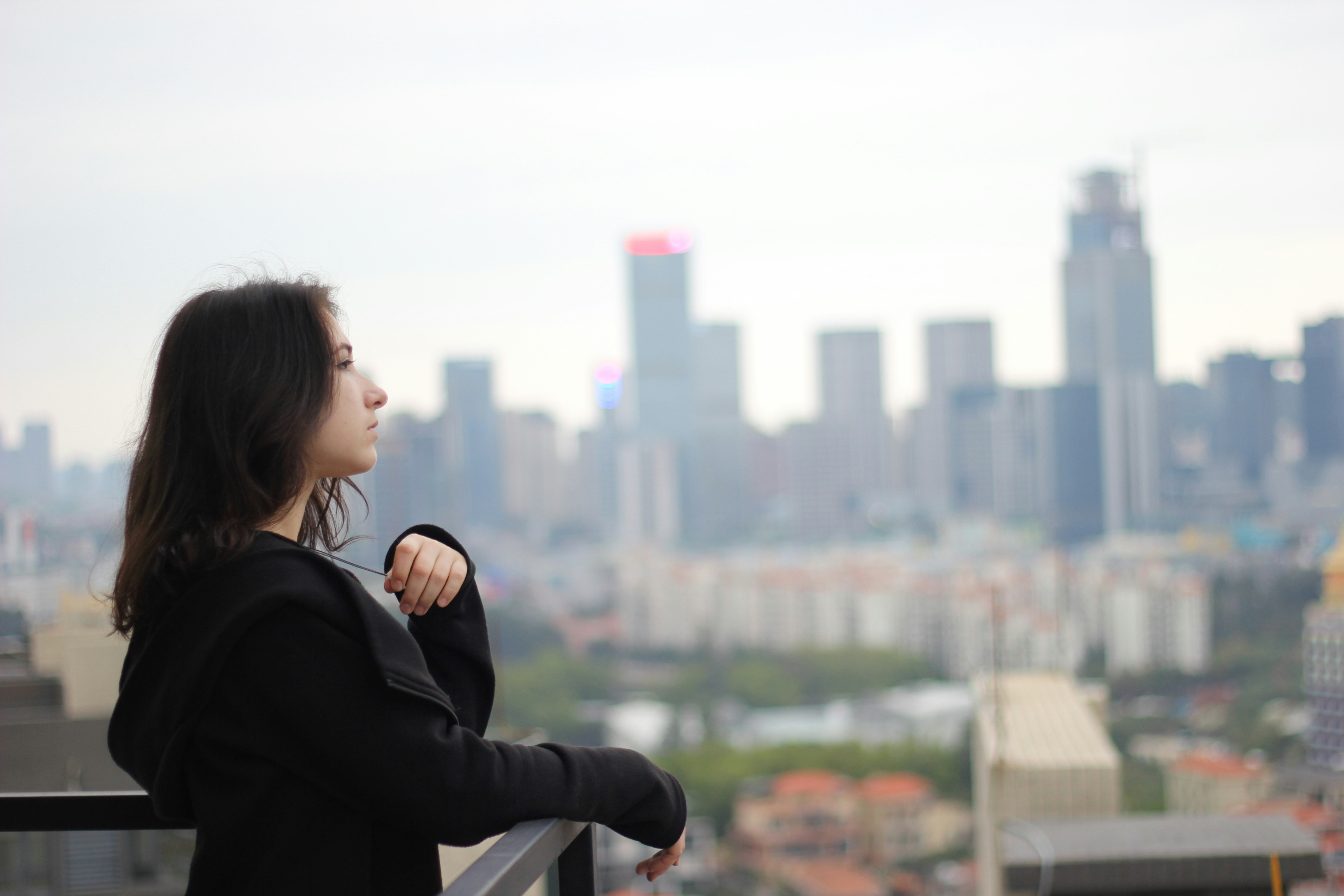 woman in black long sleeve shirt looking at the city during daytime