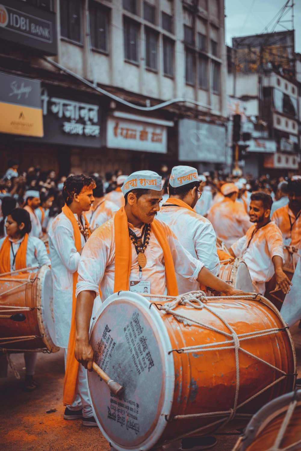 people in white long sleeve shirt and black hat playing musical instruments on street during daytime