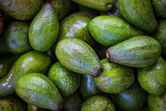 Close-up of fresh avocados and limes ready for export packaging.