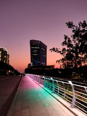 A sleek digital bridge glowing over a futuristic cityscape at dusk, symbolizing connection and innovation.