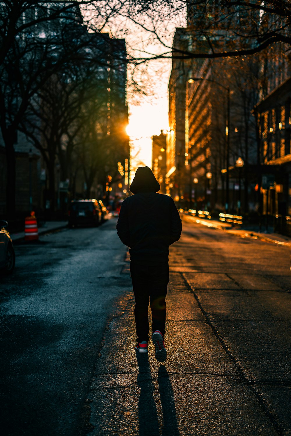 man in black jacket and black pants standing on sidewalk during daytime