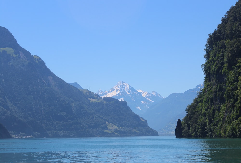 body of water near mountain during daytime