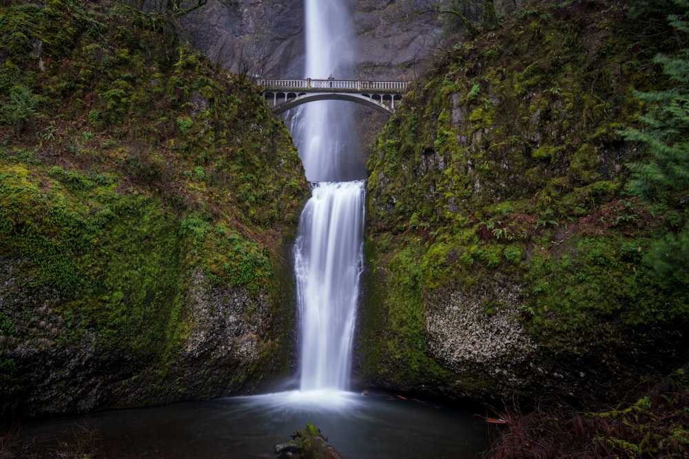 waterfalls under bridge during daytime