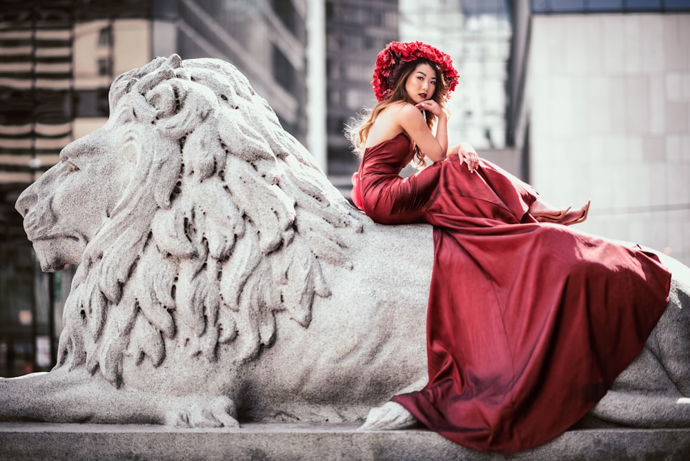 Femme en hijab rouge assise sur un banc en béton