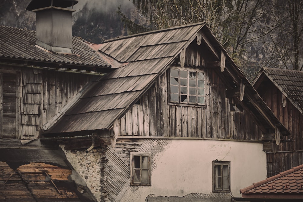 brown wooden house near green trees during daytime