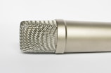 Close-up of a sleek microphone with a modern design on a clean white background