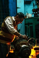Technician performing maintenance on electrical machinery in a workshop.