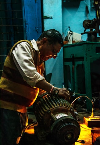 man in white and black stripe long sleeve shirt holding gray metal tool