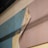 A section of wallpaper is peeling away from the wall, revealing an older, worn surface underneath with layers of blue and beige paint. The texture of the wallpaper is visible with some discoloration and possible mold spots.