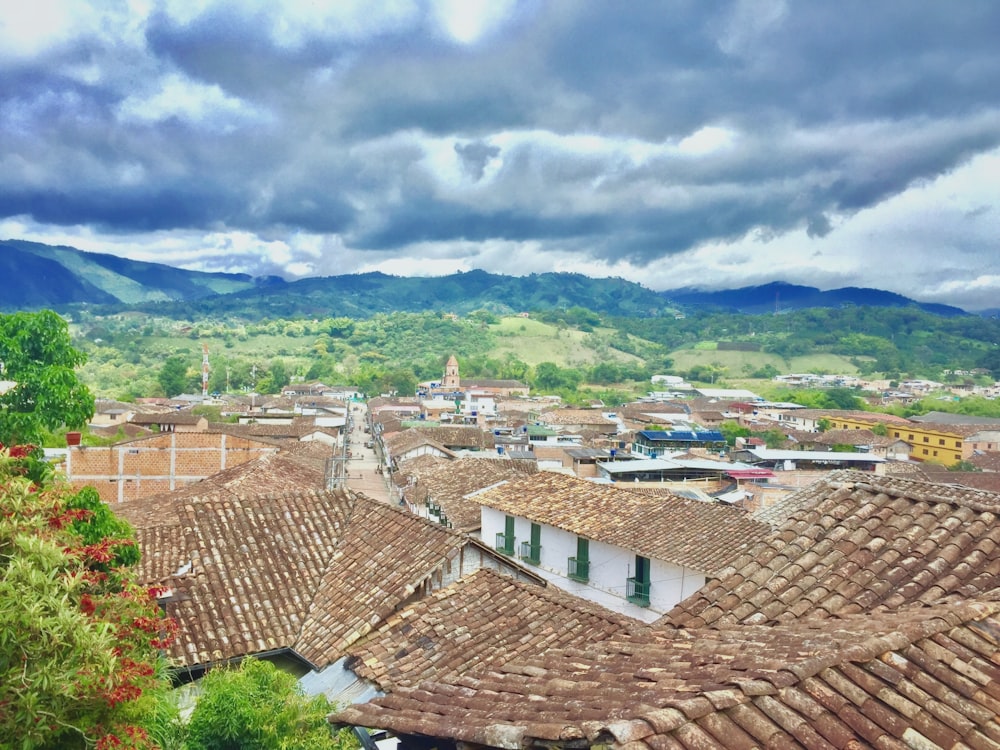 brown and white concrete houses under white clouds and blue sky during daytime