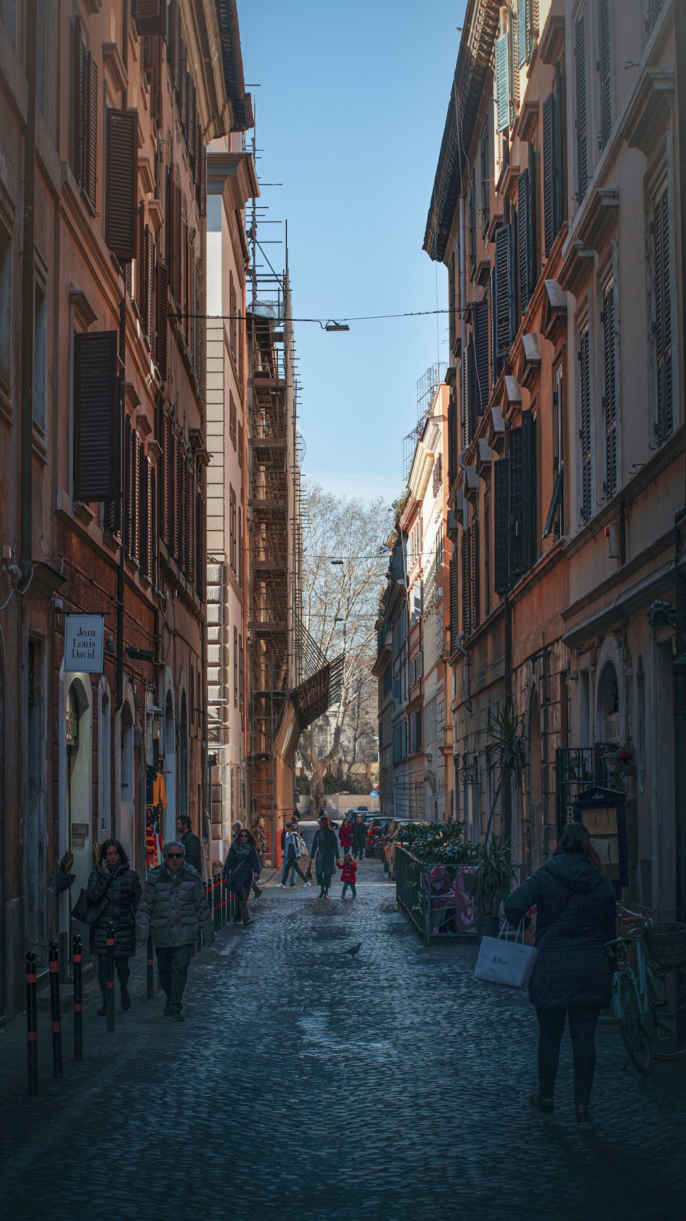 people walking on street between buildings during daytime