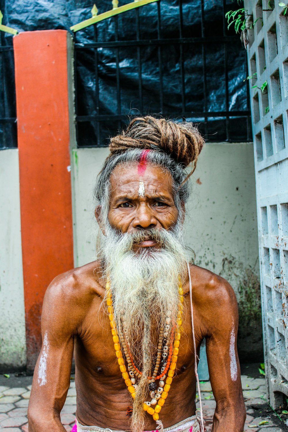 topless man with brown hair and white beard