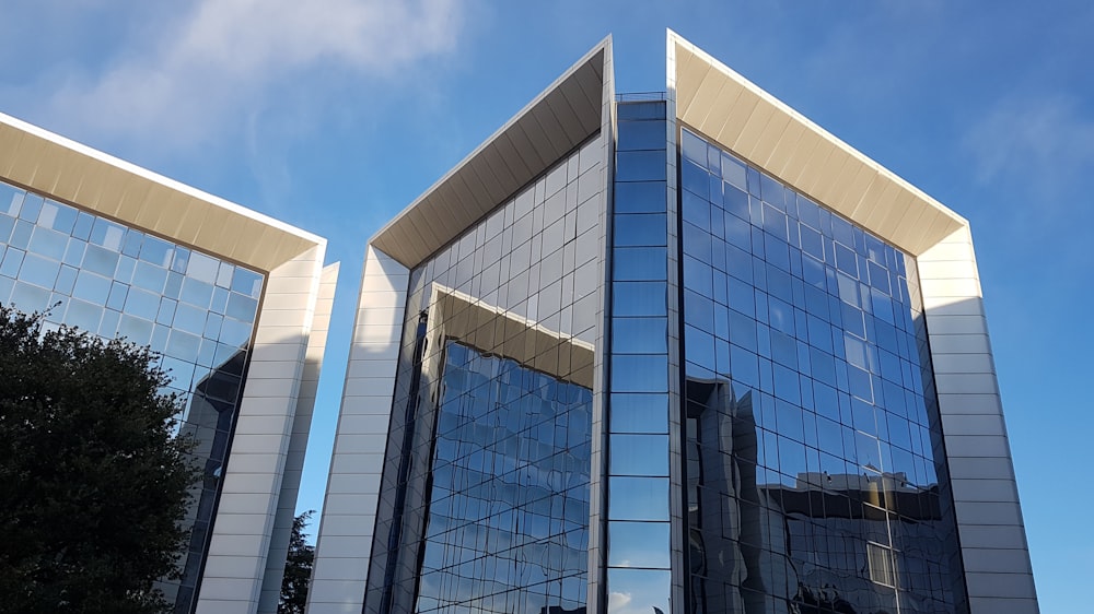 blau-weißes Gebäude mit Glaswänden unter blauem Himmel tagsüber