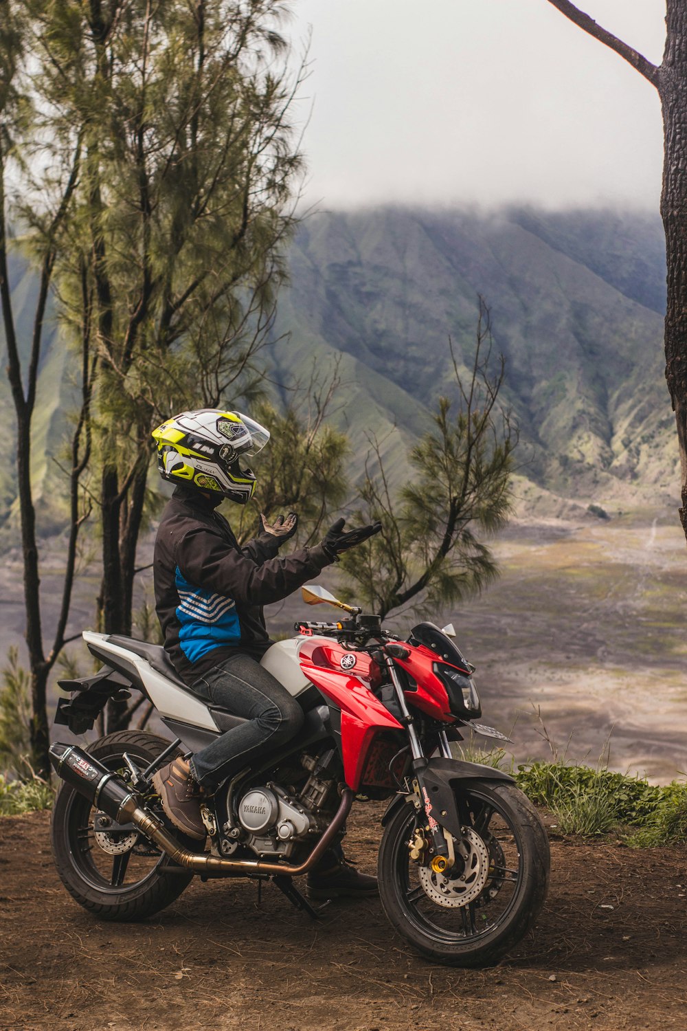 man in black helmet riding red and black sports bike