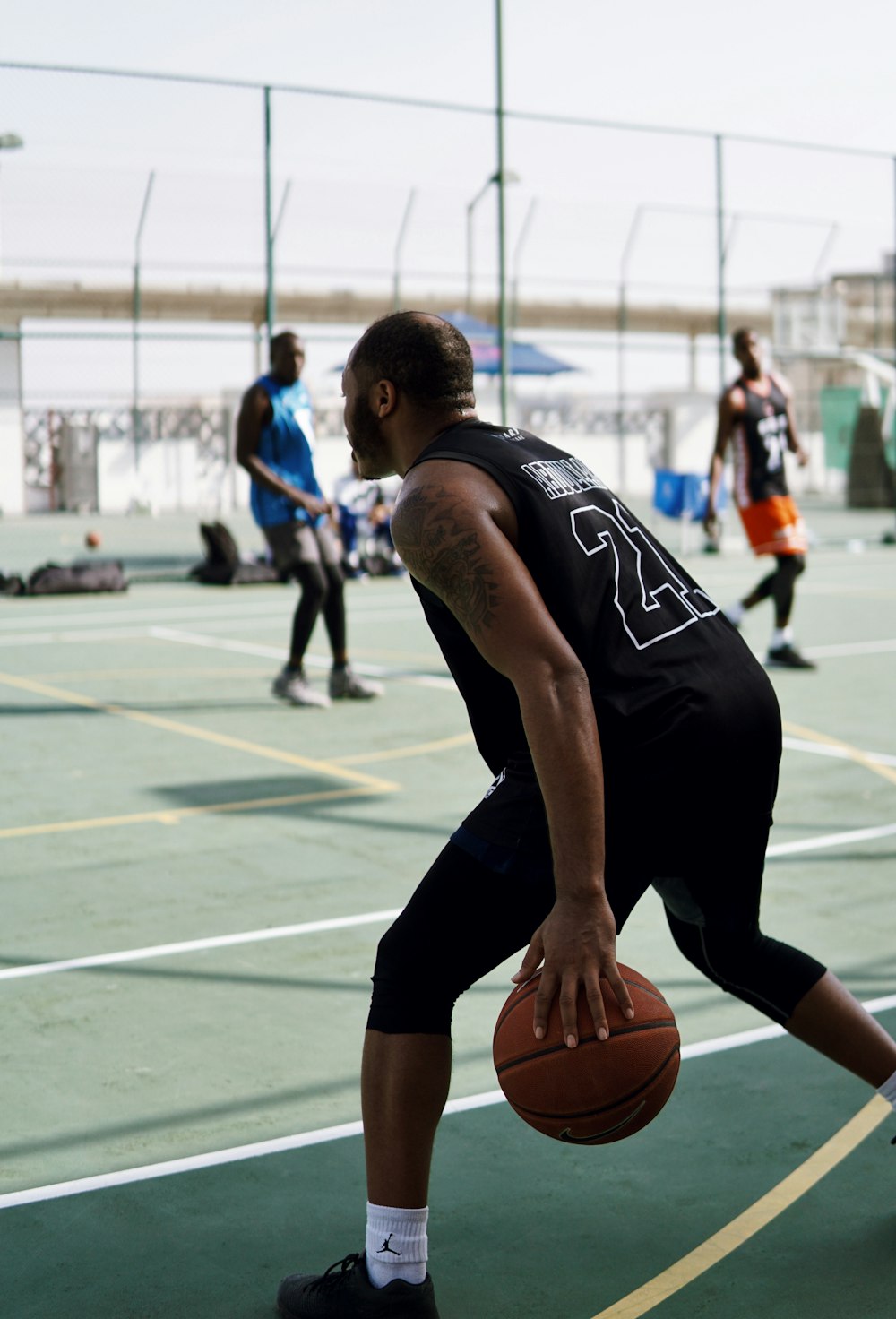 man in black tank top and shorts holding basketball