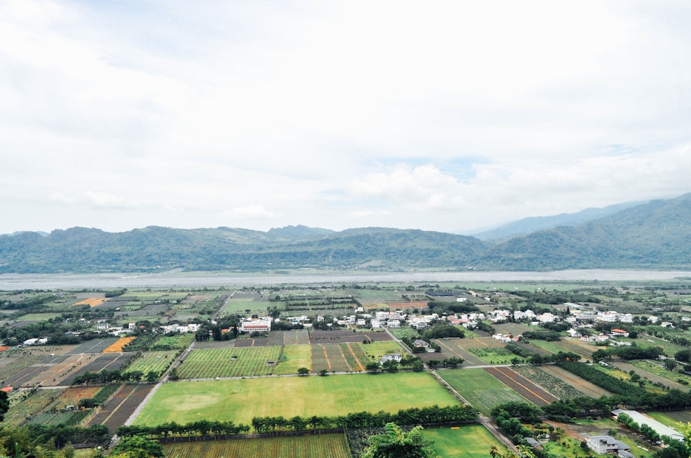 Vista aérea de un campo de hierba verde y montañas verdes durante el día