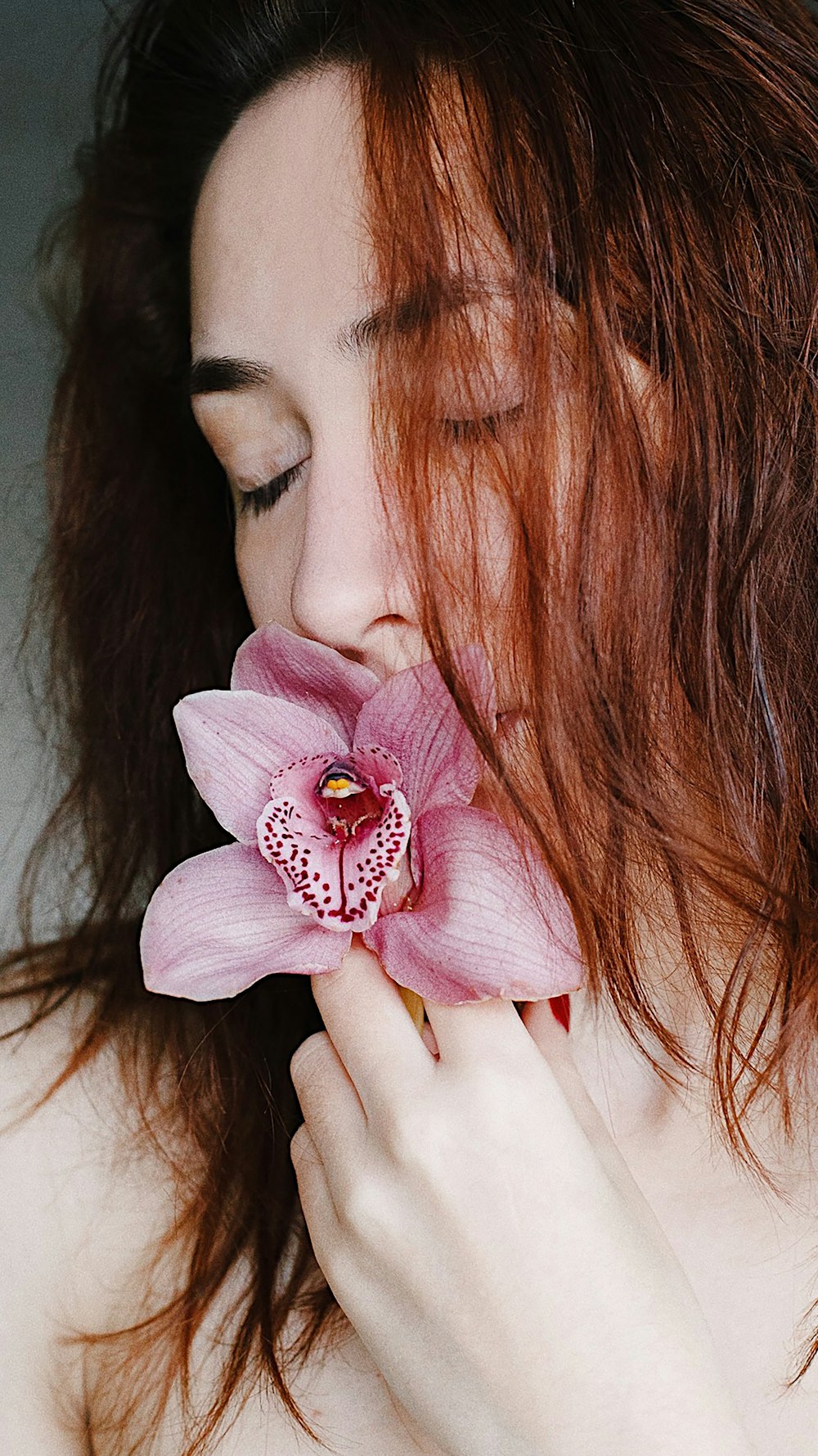 woman with pink flower on her ear