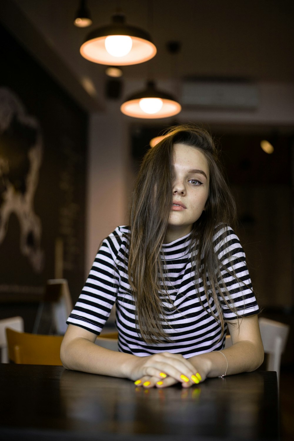 woman in black and white striped shirt sitting on chair