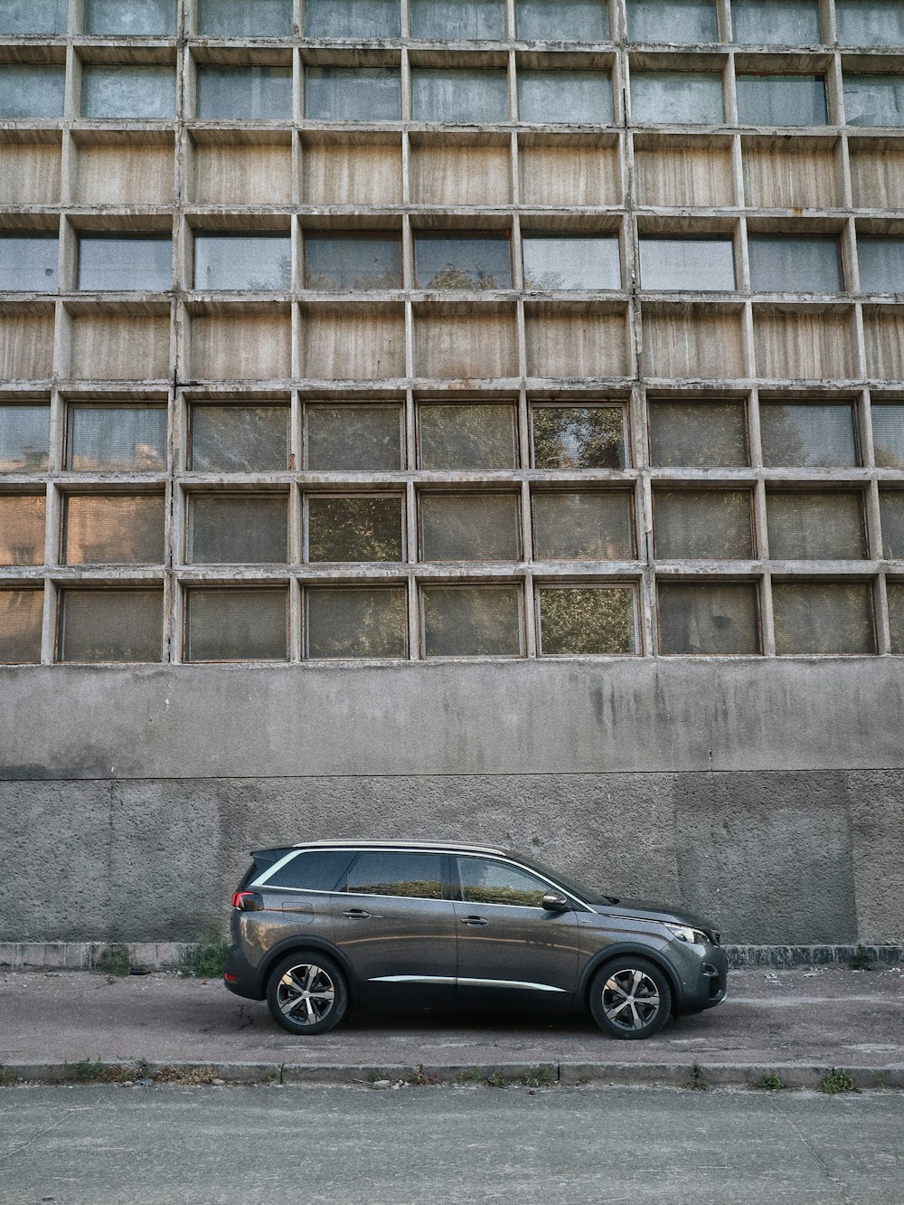 berlina nera parcheggiata accanto all'edificio in cemento marrone