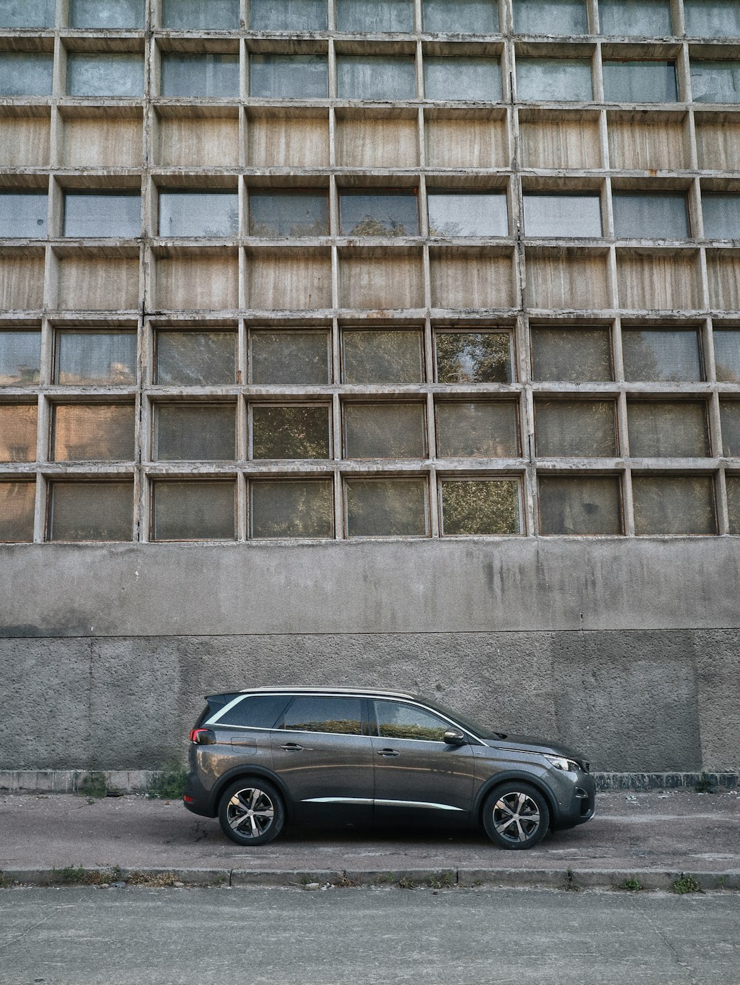 black sedan parked beside brown concrete building