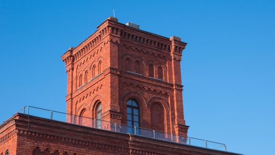 brown concrete building under blue sky during daytime in Łódź Poland