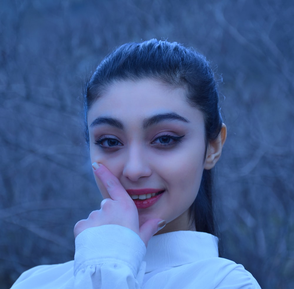 smiling woman in white long sleeve shirt