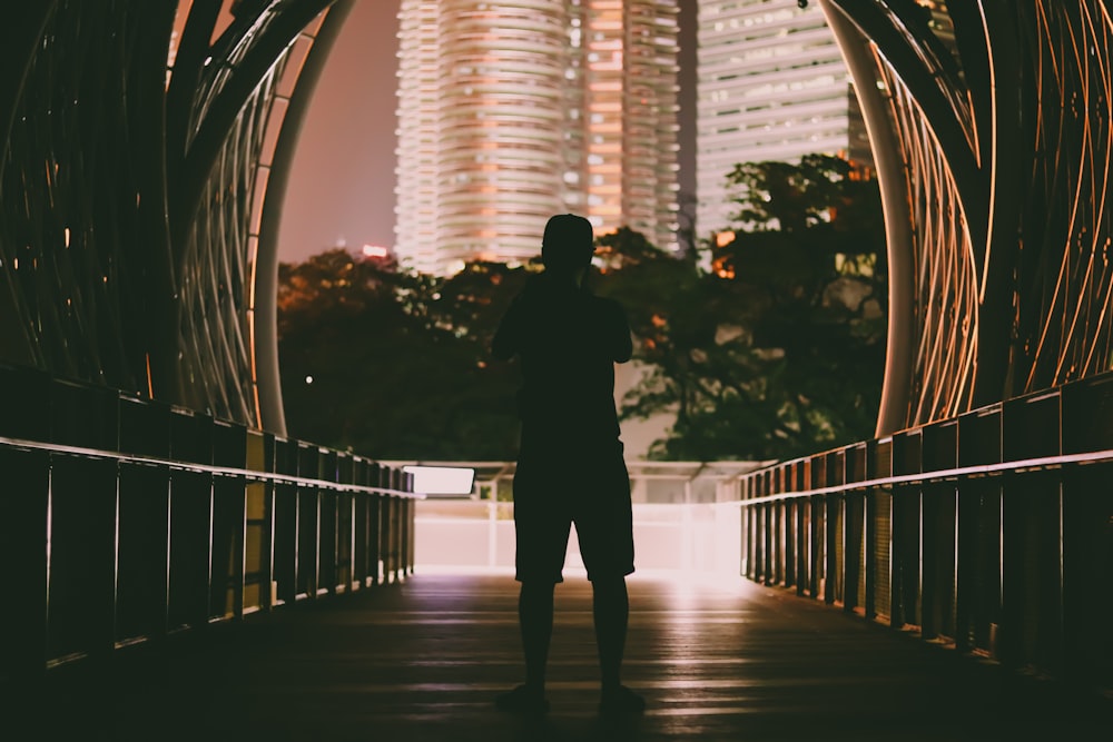 silhouette dell'uomo in piedi sul ponte durante il giorno