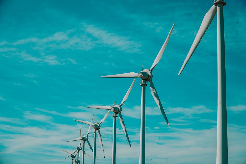 a row of wind turbines against a blue sky