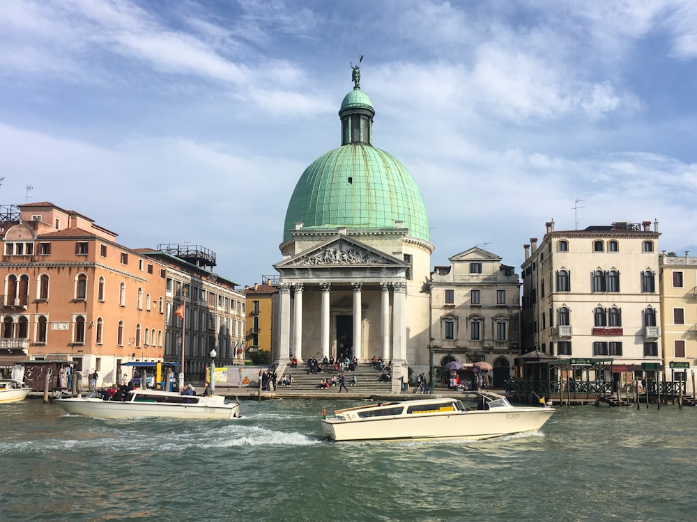 white and blue boat on water near building during daytime