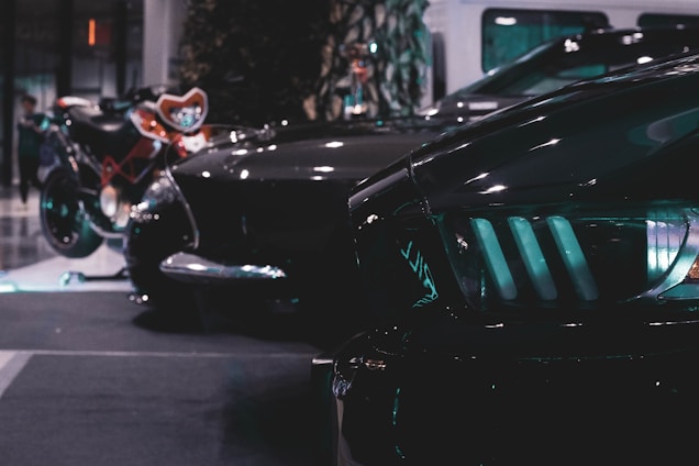 A dark-themed, stylish display of various car lamps and parts arranged neatly with subtle lighting highlighting their details.