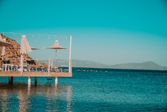 MG TURIZM A brown wooden dock on blue sea under blue sky during daytime