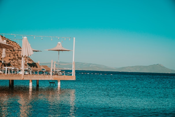 MG TURIZM A brown wooden dock on blue sea under blue sky during daytime