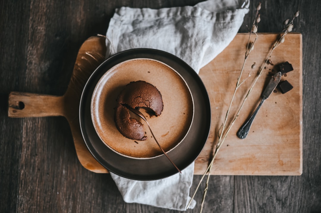 chocolate cake on black plate beside stainless steel fork and knife