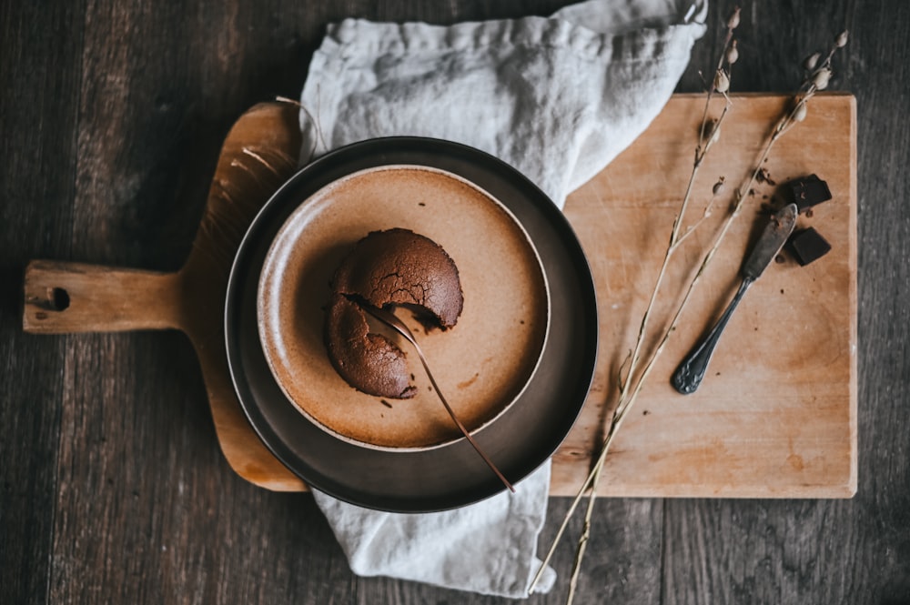 Schokoladenkuchen auf schwarzem Teller neben Edelstahlgabel und Messer